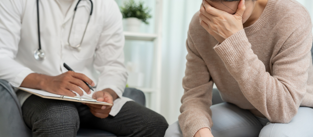 Doctor consulting a distressed patient about insomnia and mental health concerns.